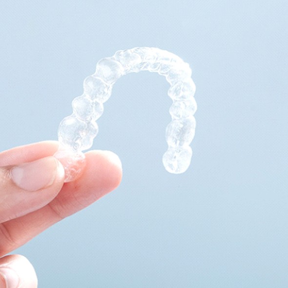 Patient holding up Invisalign in Virginia Beach tray