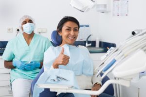 happy patient with a thumbs up and using dental insurance coverage 